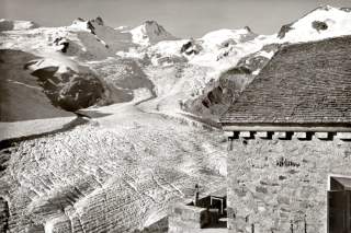Ein Foto vom Roseggletscher im Jahr 1950, im Vordergrund eine Hütte, dahinter viel Eis und Schnee.