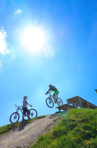 Ein Mountainbiker springt über eine kleine Rampe