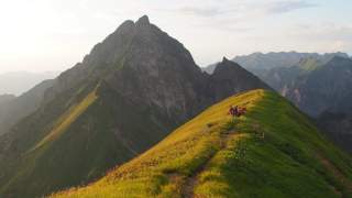 Eine Jugendgruppe genießt den tiefen Sonnenstand am Berg