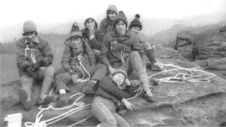 Eine Gruppe an Kindern und Jugendlichen macht Pause am Berg