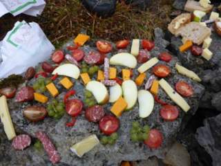 Verschiedene Lebensmittel liegen als Buffet auf einem Stein