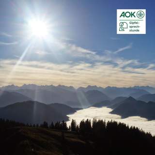 Ein sonniger Tag in den Bergen mit Blick auf nebelverhangene Täler