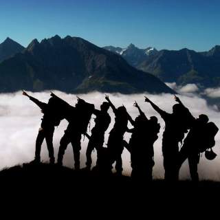 Eine Gruppe Wander*innen zeigt in die ferne