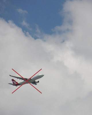 Ein Flugzeug im Himmel, darüber ein großes rotes Kreuz