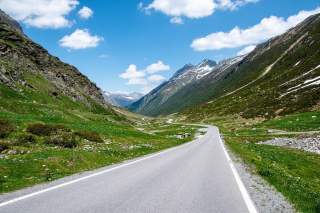 Eine Bergstraße, die in ein weites Tal führt