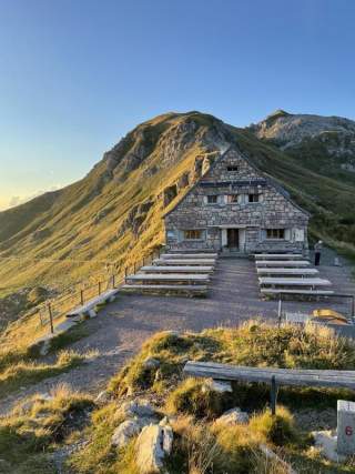 Eine Berghütte aus Stein mit großer Terrasse