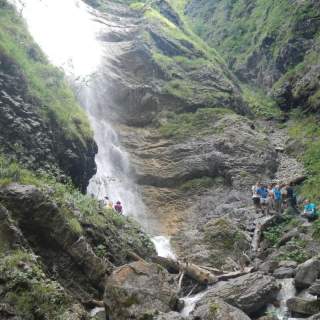 Jugendliche stehen an einem Wasserfall